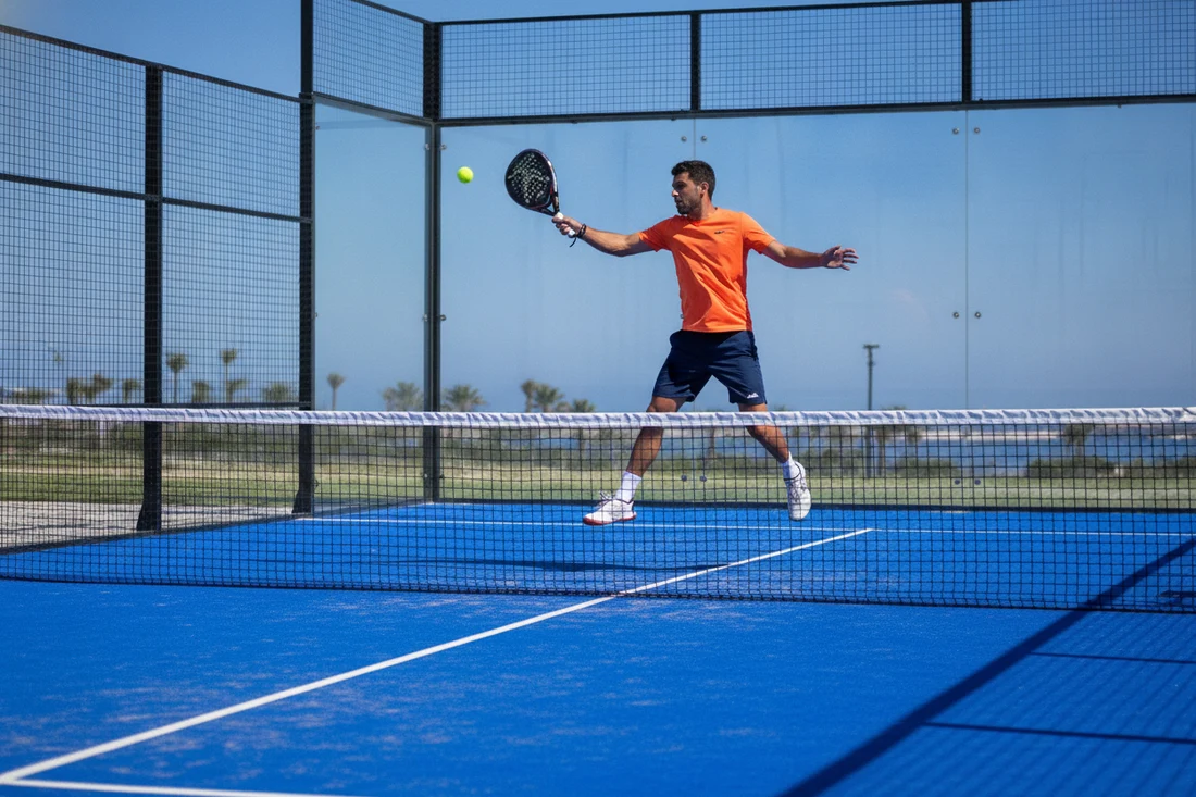 Joueur de padel frappant un coup droit en match, evaluation du niveau