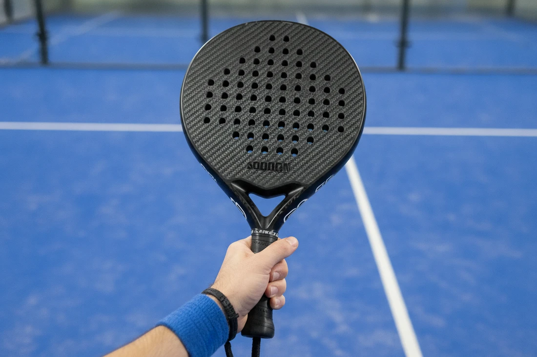 Raquette de padel pleine et perforée sans cordage, contrairement à une raquette de tennis