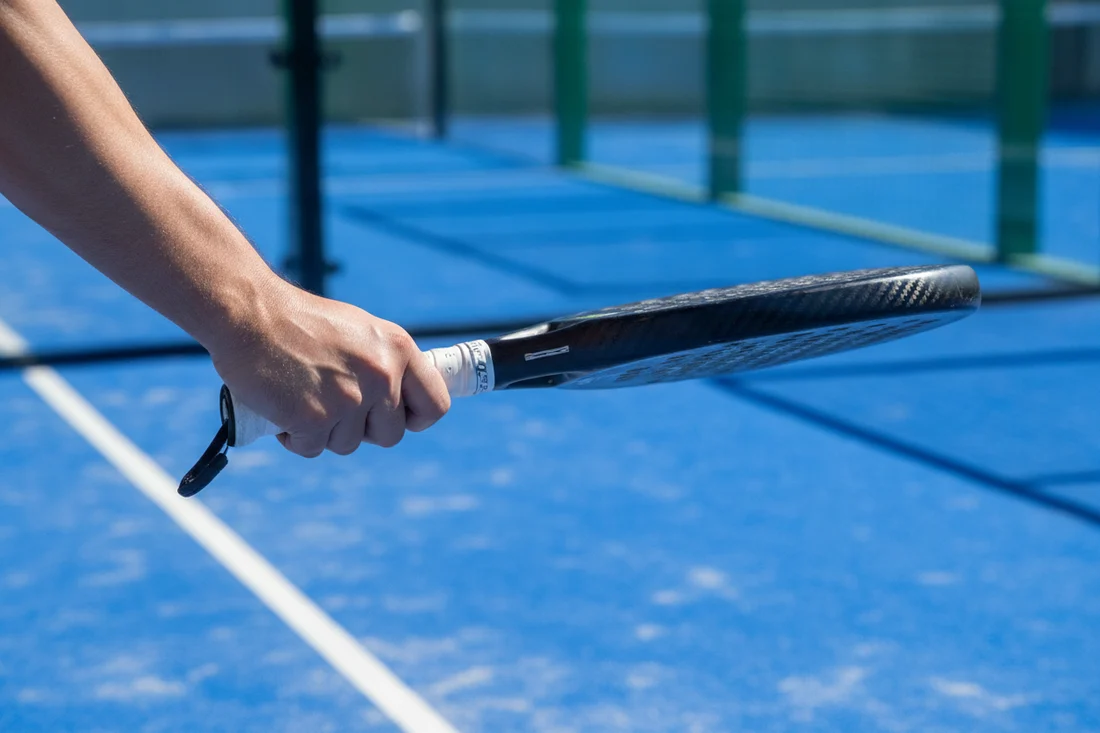Prise continentale de padel vue de cote, main sur le manche