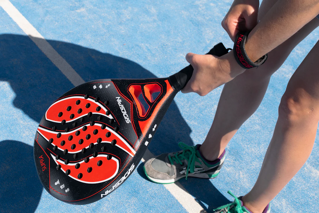 Joueuse de padel avec sa raquette pres de la vitre