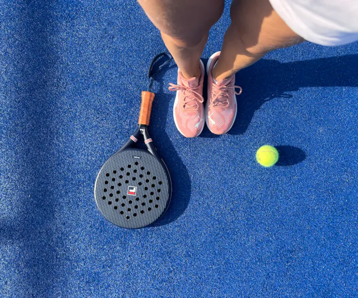 Raquette de padel et balles sur un court bleu, choisir sa raquette de padel