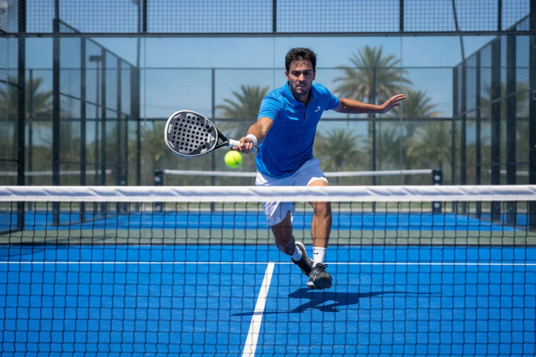Joueur de padel a la volee au filet pendant un point