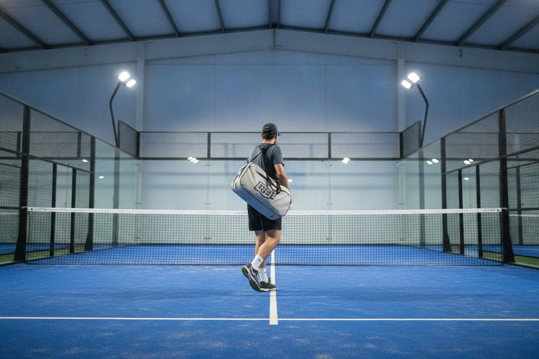 Joueur portant un paletero dans un club de padel indoor