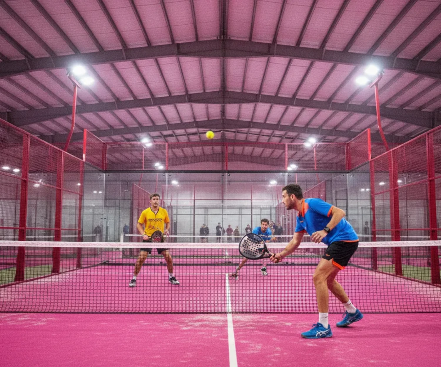 Amortie au padel : joueur jouant une amortie tout en finesse au filet, match en double en salle indoor sur court rose