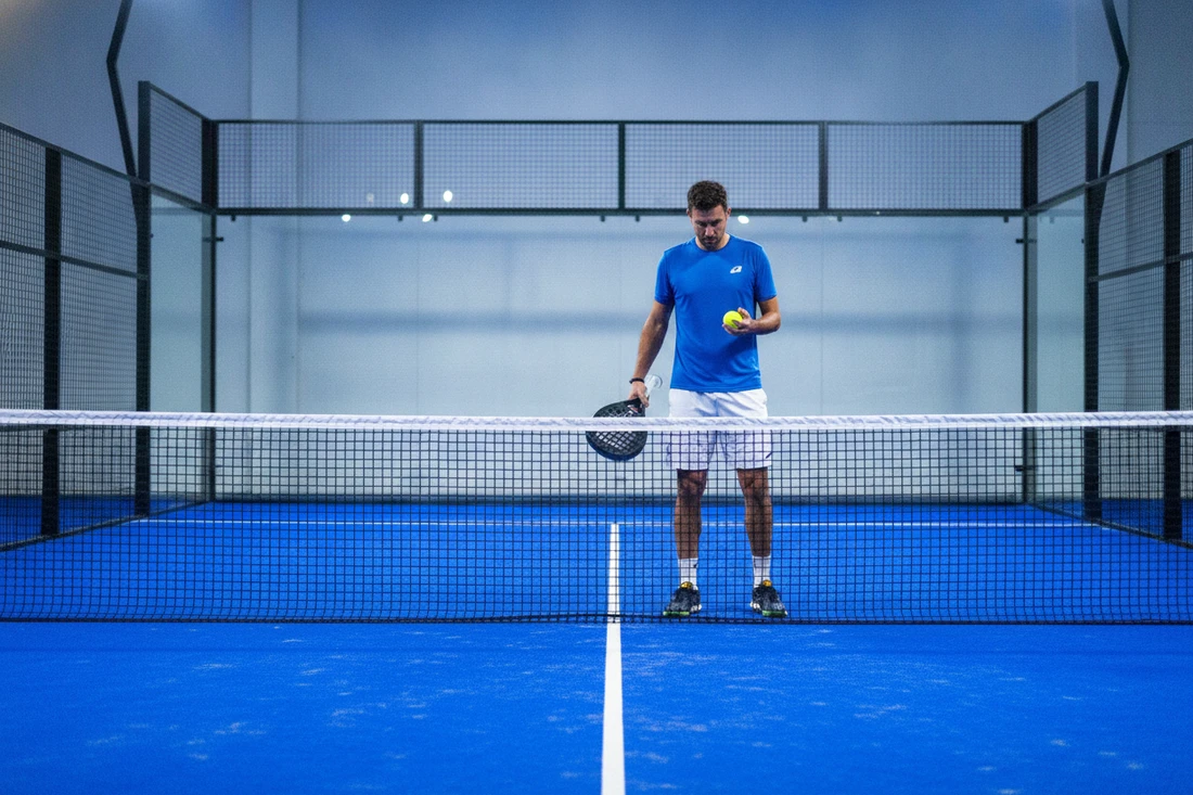 Quand choisir une balle de padel rapide ou lente, joueur examinant sa balle