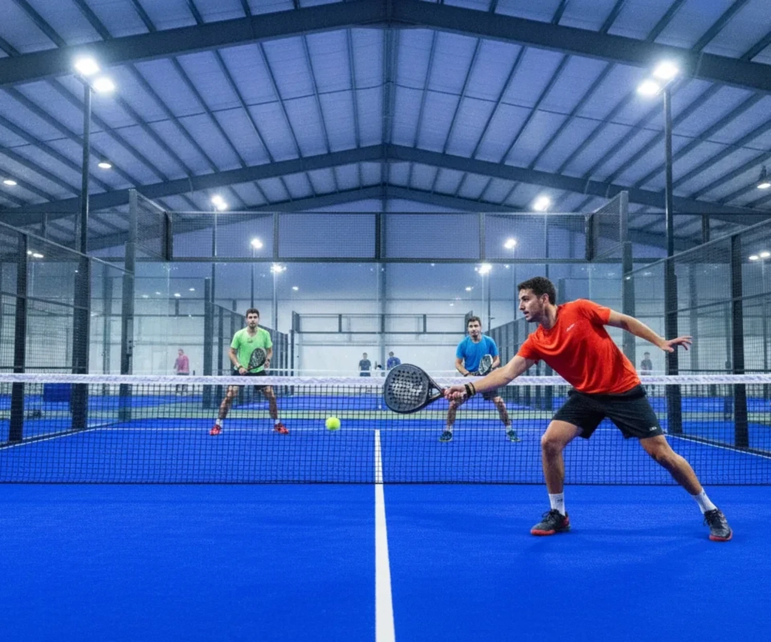 Balle de padel rapide ou lente : échange en double sur court indoor bleu, joueur frappant la balle