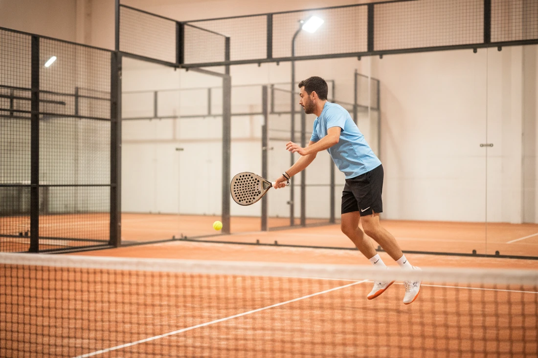 Joueur frappant avec une raquette de padel en goutte d'eau