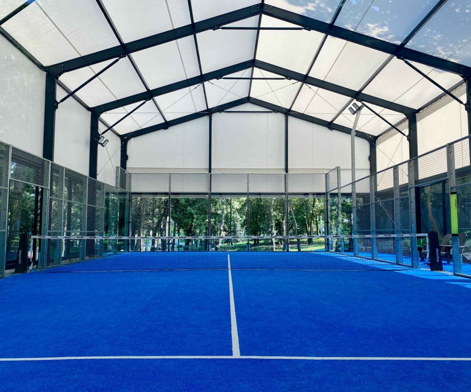 Court de padel intérieur vitré au sol bleu, illustration du lexique du padel
