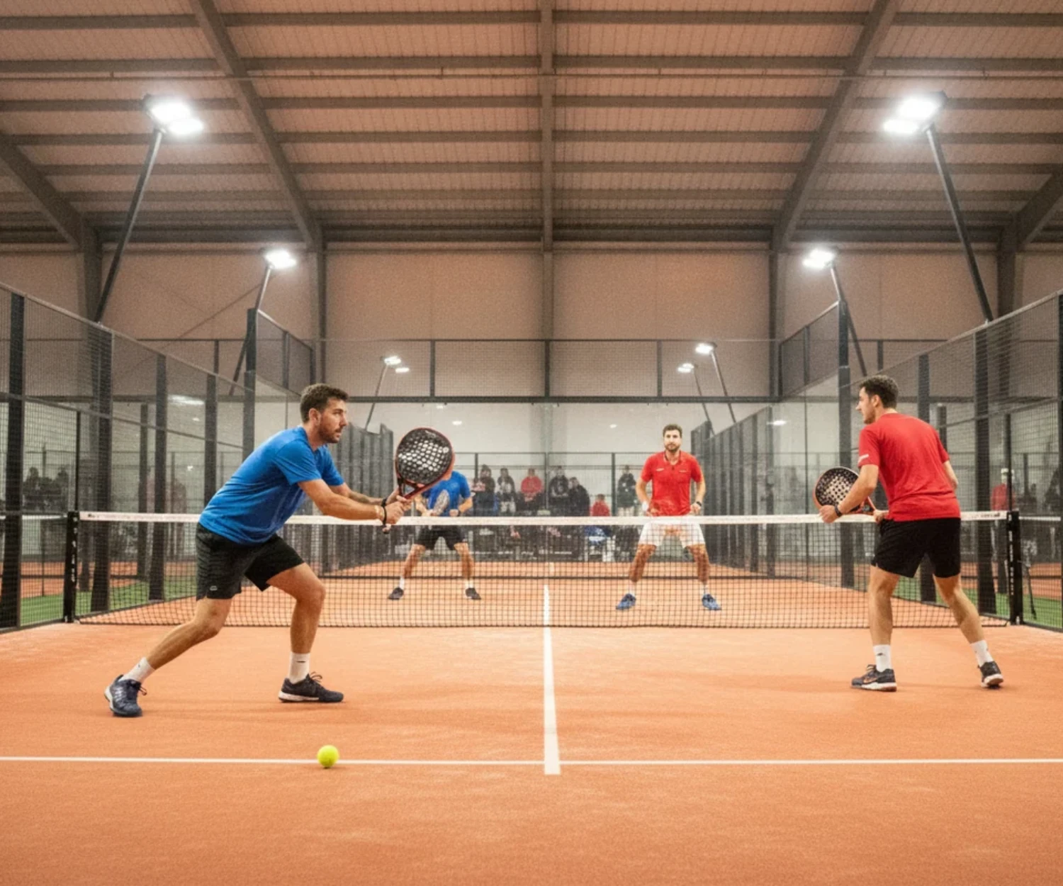 P25 padel : match de competition en double dans une salle indoor sur court orange, ambiance premier tournoi
