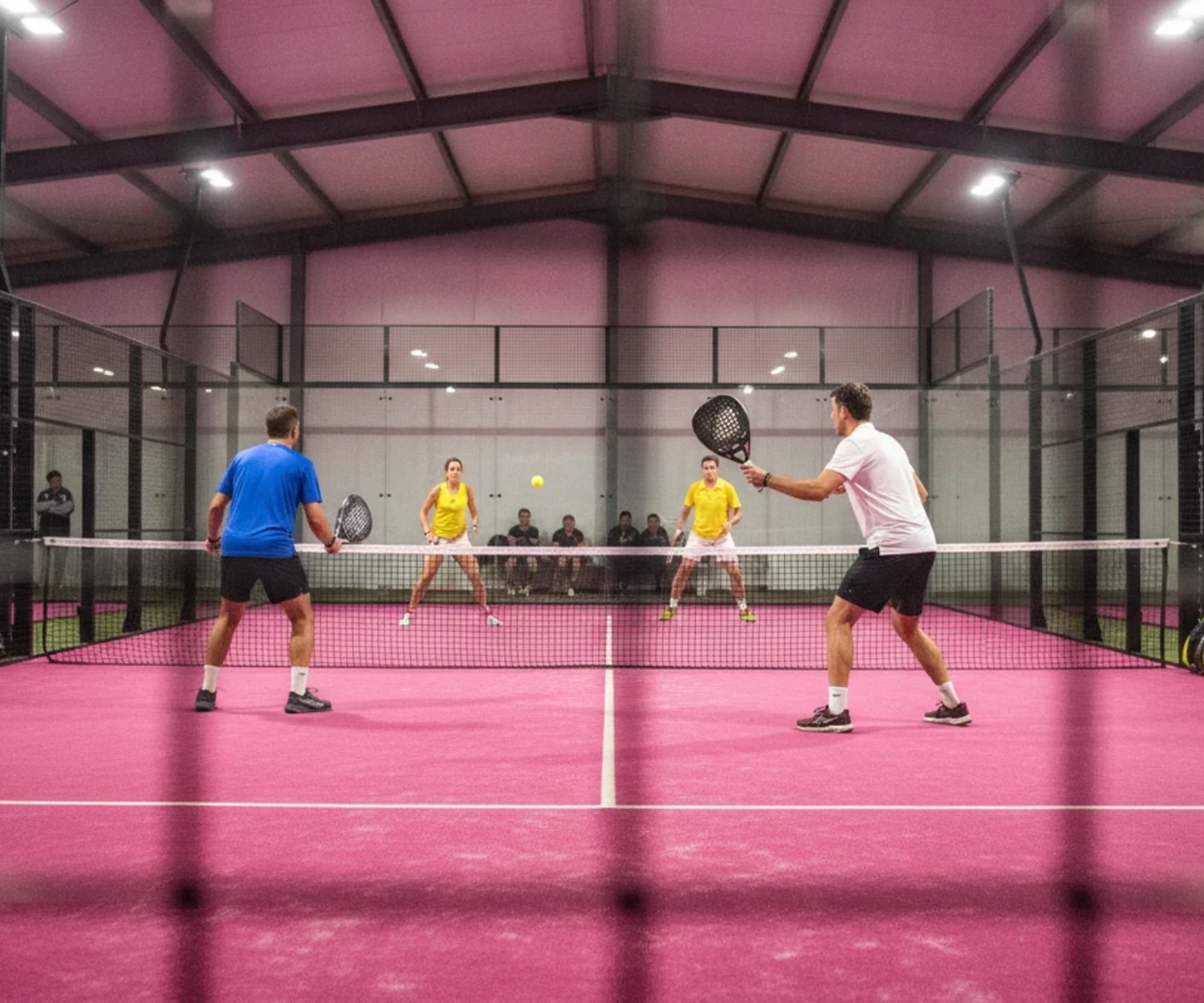 Tournoi P25 de padel : match de double vu à travers le grillage devant des spectateurs