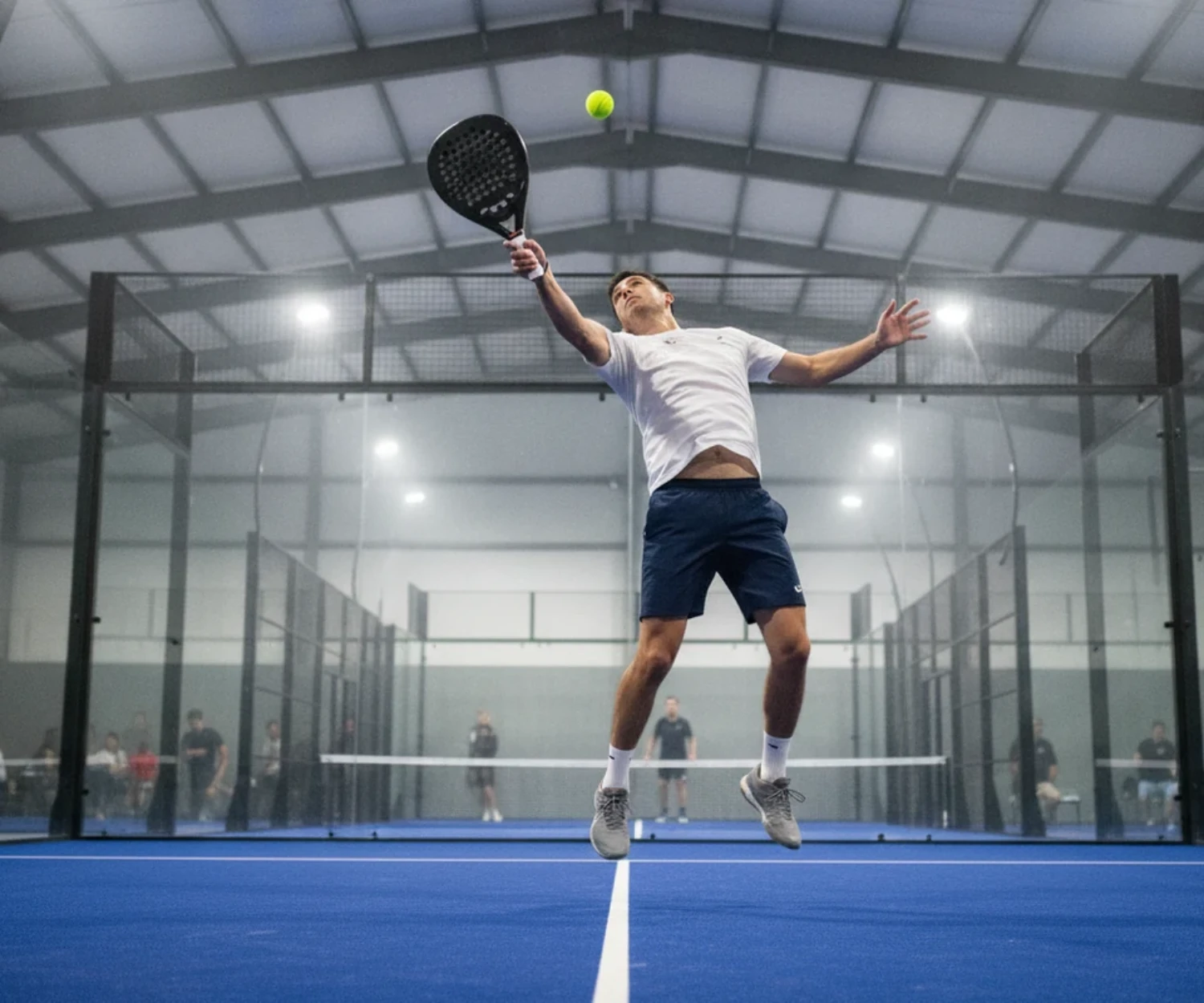 Smash au padel sur une piste indoor bleue, illustration du padel a Vannes
