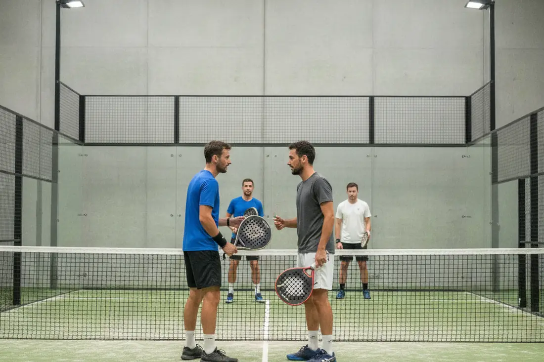 Paire de padel discutant sa stratégie entre deux points, choix entre P100 et P250
