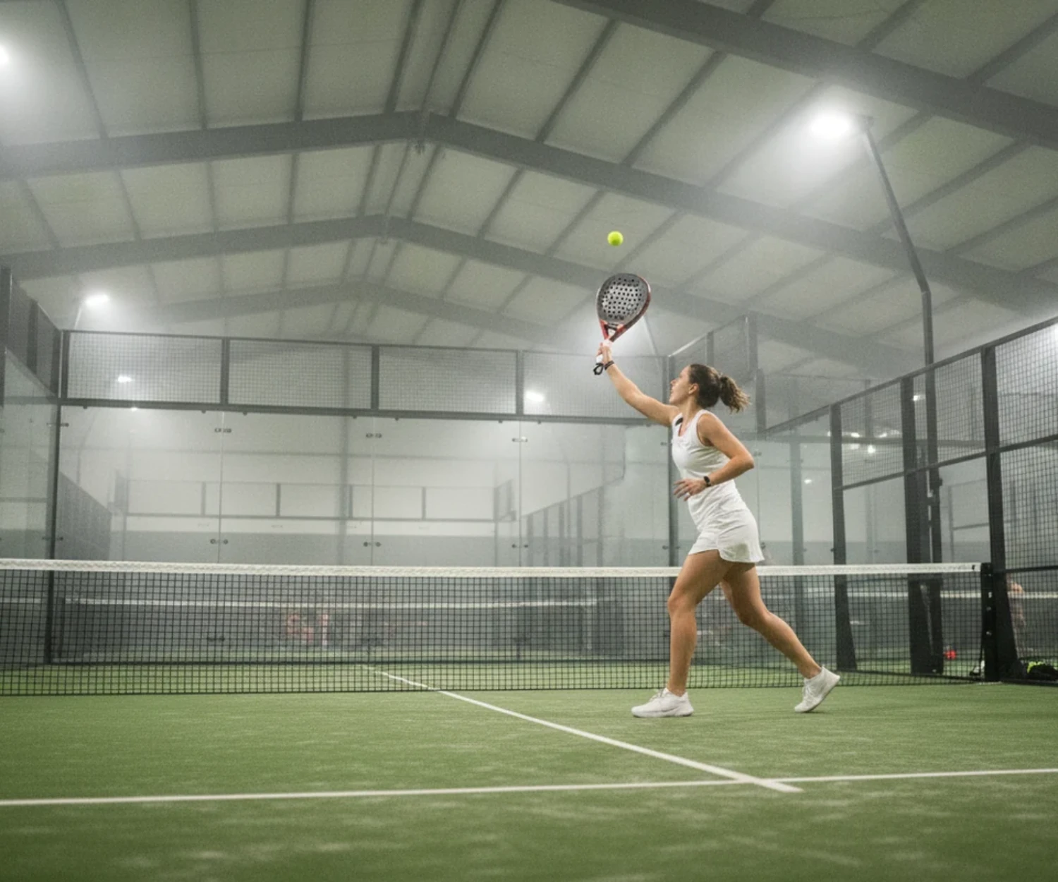 Joueuse de padel frappant une volée haute au filet, choix d une raquette de padel femme