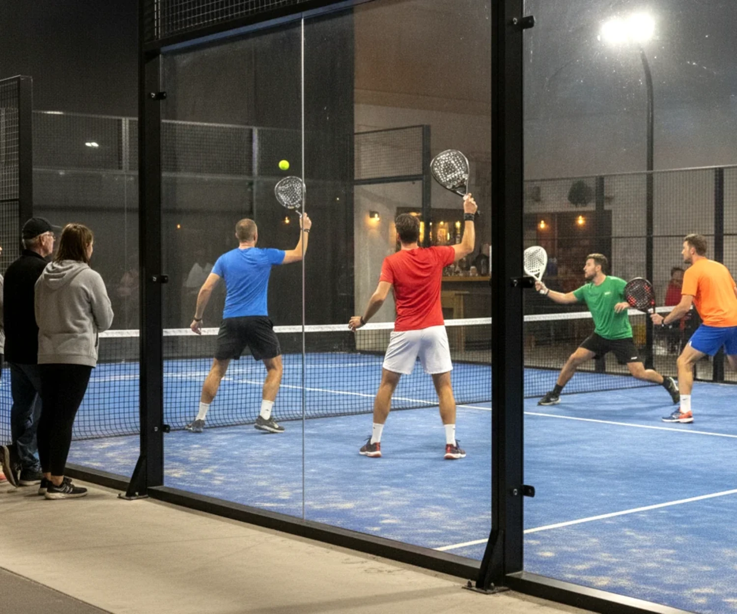 Spectateurs derrière la vitre pendant un match de double d'un tournoi P250 de padel en salle