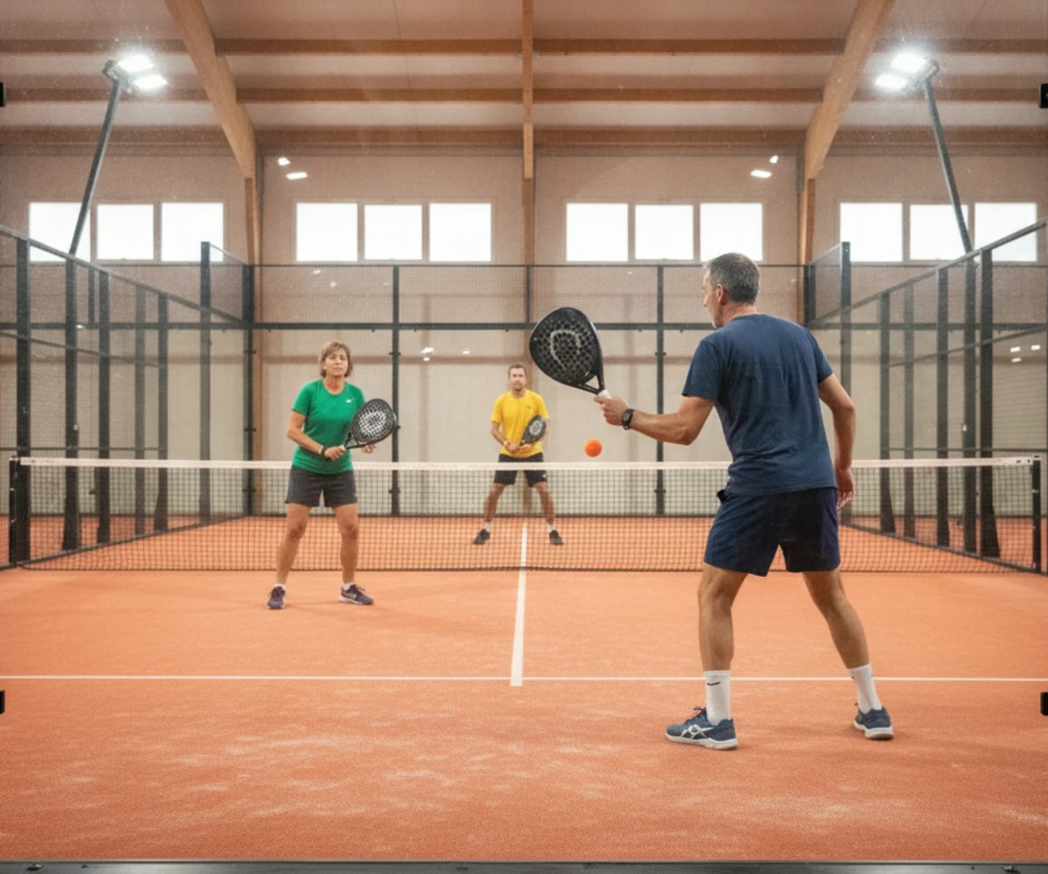 Joueur de padel vu de dos derrière la vitre du fond pendant un match de tournoi P500